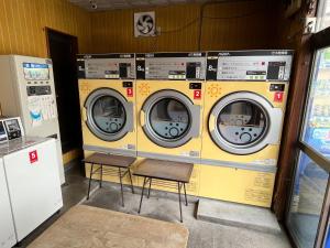 four washing machines in a room with two chairs at BISK PARK TOKYO - 4LDK Spacious House - Easy Access to Asakusa, Skytree area & Airport in Tokyo