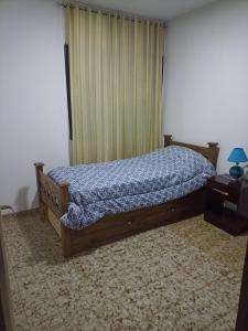a bedroom with a bed with a blue comforter at Depto 4-6 Personas in San Juan