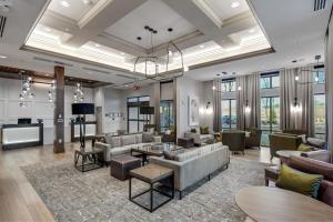 salon z kanapami, stołami i oknami w obiekcie Residence Inn by Marriott Atlanta Covington w mieście Covington