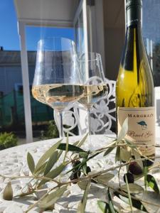 a bottle of wine and two glasses on a table at Petite on Regent in Martinborough 