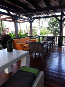 a patio with couches and tables and chairs at Villa in Aruba's nature's paradise in Santa Cruz