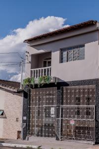 uma casa com uma cerca de ferro em frente em Wabisabi Residence em Araxá