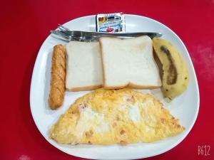 a plate of breakfast food with eggs sausage and bananas at Vientiane Memory Hotel in Vientiane