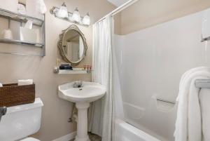 a white bathroom with a sink and a mirror at Historic Branson Hotel - Serendipity Room with Queen Bed - Downtown - FREE TICKETS INCLUDED in Branson