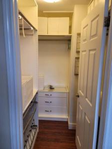 a walkin closet with white cabinets and a door at Serene in Halifax