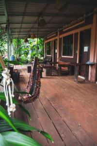 eine Veranda mit Stühlen und Tischen auf einem Haus in der Unterkunft FamilyHouse & Trekking in Banlung