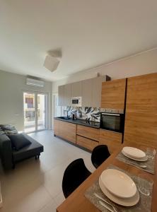 uma cozinha e sala de estar com mesa e cadeiras em Appartamento al Mare Sant’Agata em Messina