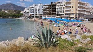 a beach with a bunch of people in the water at Atlantis Hotel in Agios Nikolaos
