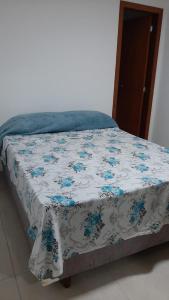 ein Bett mit einer blauen und weißen Decke drauf in der Unterkunft Jockey Family_Villaggio di Piazza in Vila Velha