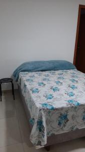 a bed with a blue and white blanket on it at Jockey Family_Villaggio di Piazza in Vila Velha
