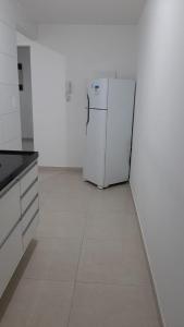 a kitchen with a white refrigerator in a room at Jockey Family_Villaggio di Piazza in Vila Velha