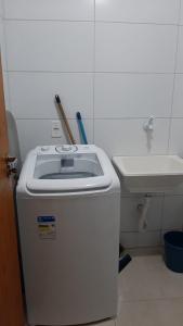 ein Badezimmer mit einem Mülleimer und einem Waschbecken in der Unterkunft Jockey Family_Villaggio di Piazza in Vila Velha
