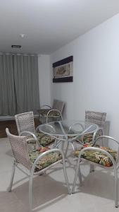 eine Gruppe von Stühlen sowie ein Glastisch und Stühle in der Unterkunft Jockey Family_Villaggio di Piazza in Vila Velha