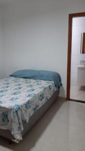 ein Schlafzimmer mit einem Bett mit einer blau-weißen Decke in der Unterkunft Jockey Family_Villaggio di Piazza in Vila Velha