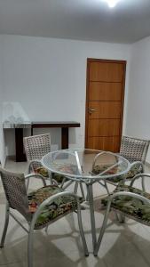 uma mesa de vidro e cadeiras num quarto em Jockey Family_Villaggio di Piazza em Vila Velha