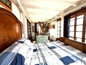 1 dormitorio con 1 cama, vestidor y ventanas en La Casa Azul del Ventorrillo: Hospedaje Historico en Bogotá