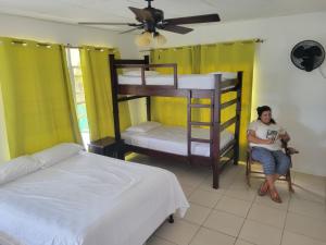 a woman sitting in a chair in a room with bunk beds at Ocean View in Big Corn Island
