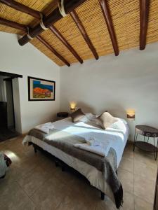 a bedroom with a large bed with a wooden ceiling at Hostería Aguas Coloradas in Purmamarca