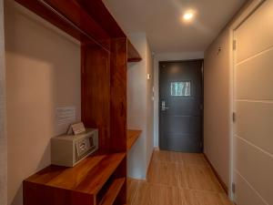 a hallway with a room with a door and a microwave at MIRAFLORES CITY HOTEL in Lima