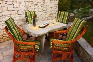 a table with four chairs and a bottle of wine at Holiday Home Olea in Splitska