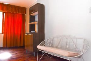 a room with a bed and a cabinet with curtains at Las Mariposas Hospedaje in Tacna