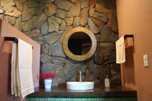 baño con lavabo y pared de piedra en Mi casa de Valle en Valle de Bravo