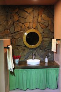 baño con lavabo y pared de piedra en Mi casa de Valle en Valle de Bravo