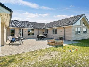 a patio with chairs and a table in front of a house at Luxury Retreat by Houstrup - By Traum Ferienwohnungen in Nørre Nebel