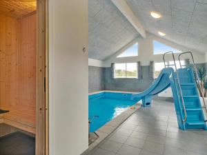 a indoor swimming pool with a slide in a house at Luxury Retreat by Houstrup - By Traum Ferienwohnungen in Nørre Nebel