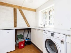 a laundry room with a washing machine and a sink at Holiday home Guldborg II in Guldborg