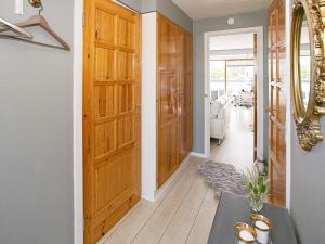 korytarz z drewnianymi drzwiami i stołem w obiekcie Holiday home Tranekær IX w mieście Tranekær