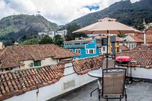una mesa con sombrilla en la azotea en La Casa Azul del Ventorrillo: Hospedaje Historico en Bogotá