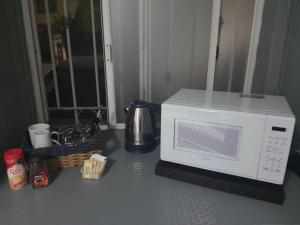 un microondas sentado en un mostrador de cocina junto a una mesa en Cómoda Habitación en fraccionamiento privado, en León