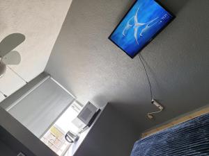 TV de pantalla plana en el techo de una habitación en Cómoda Habitación en fraccionamiento privado, en León