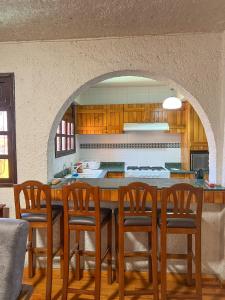 Hotel RJ Querétaro في كيريتارو: مطبخ مع طاولة مع كراسي وكاونتر