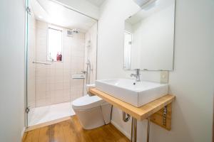 a bathroom with a sink and a toilet and a shower at Alps Retreat Chalet by Morino in Hakuba