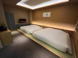 a small room with two beds and a tv at Kuriya Suizan in Jozankei