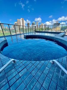 een zwembad met blauw water in een stad bij Ilusion: perto de tudo em Ponta Negra - AlfaTemporada in Natal