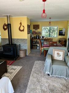 a living room with a couch and a stove at Karikari Lodge in Tokerau Beach