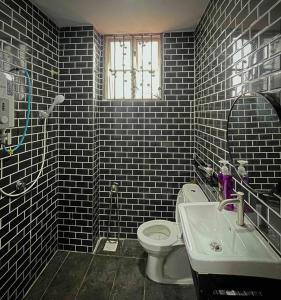a bathroom with a white toilet and a sink at Homestay Desa (Bukit Baru, Melaka) in Melaka