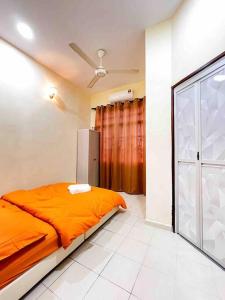 - une chambre avec un lit orange et une fenêtre dans l'établissement Homestay Desa (Bukit Baru, Melaka), à Malacca