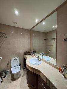 Luxueux appartement à la Marina d’agadir في أغادير: حمام مع مرحاض ومرآة كبيرة