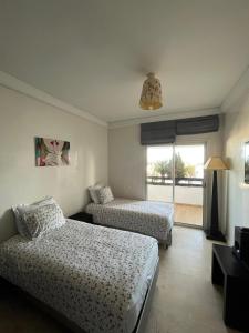 a hotel room with two beds and a window at Luxueux appartement à la Marina d’agadir in Agadir