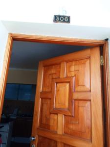 a wooden door with a clock on top of it at Paiva in Lima