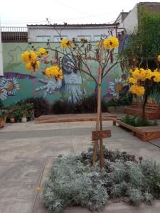a tree with yellow flowers in front of a wall at Paiva in Lima