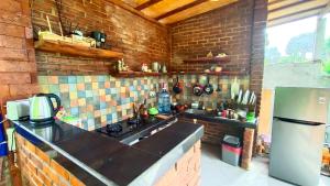 een keuken met een wastafel en een bakstenen muur bij Morning Bali Bungalow in Canggu