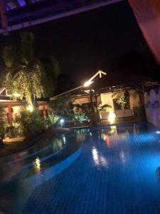 a large swimming pool at night with lights at Baan Tropicana in Mae Nam