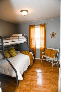 a bedroom with a bunk bed and a chair at 5 Star with Direct Access to Brimstone Recreation Game Room Comfortable Up to 4 Bedrooms Stylish in Huntsville