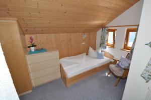 ein kleines Schlafzimmer mit einem Bett und einem Stuhl in der Unterkunft Haus Müller in Fiss