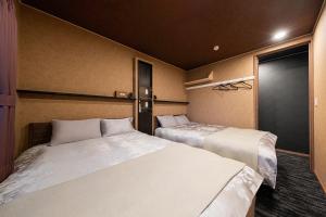 dwa łóżka w małym pokoju z dwoma łóżkami w obiekcie The OCEAN VISTA w mieście Shiraoi